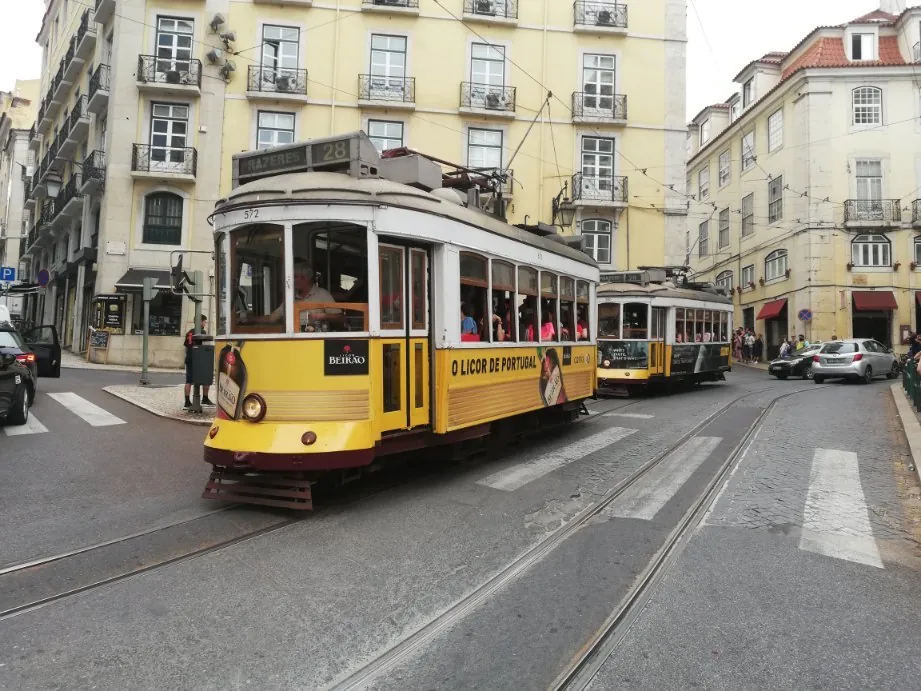 Yellow tram on a steep Alfama street at golden hour